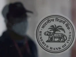 A man walks behind the Reserve Bank of India (RBI) logo inside its headquarters in Mumbai, India, April 8, 2022. REUTERS/Francis Mascarenhas/File Photo